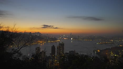 Toma-Cinematográfica-De-La-Bahía-De-Hong-Kong-Desde-Una-Colina-Distante-Durante-La-Puesta-De-Sol