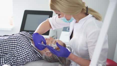procedimiento de hardware en cosmetología. el cosmetólogo suaviza las arrugas con microcorrientes. peeling, fonoforesis, masaje y lifting facial en una clínica de belleza.