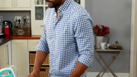 hombre planchando ropa en la cocina 4k