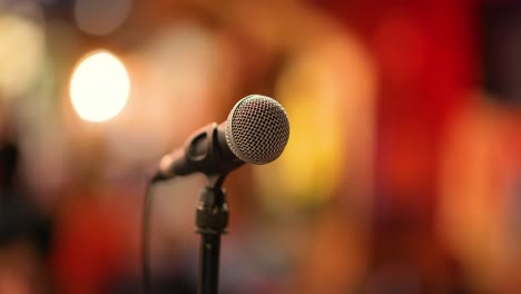 micrófono en el escenario contra un fondo de auditorio.