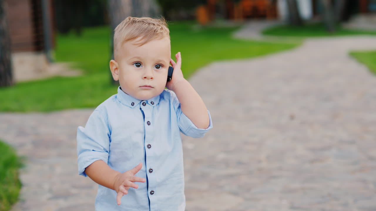 крутой годовалый ребенок играет с ключами от машины говорит по телефону как маленький бизнесмен 4k