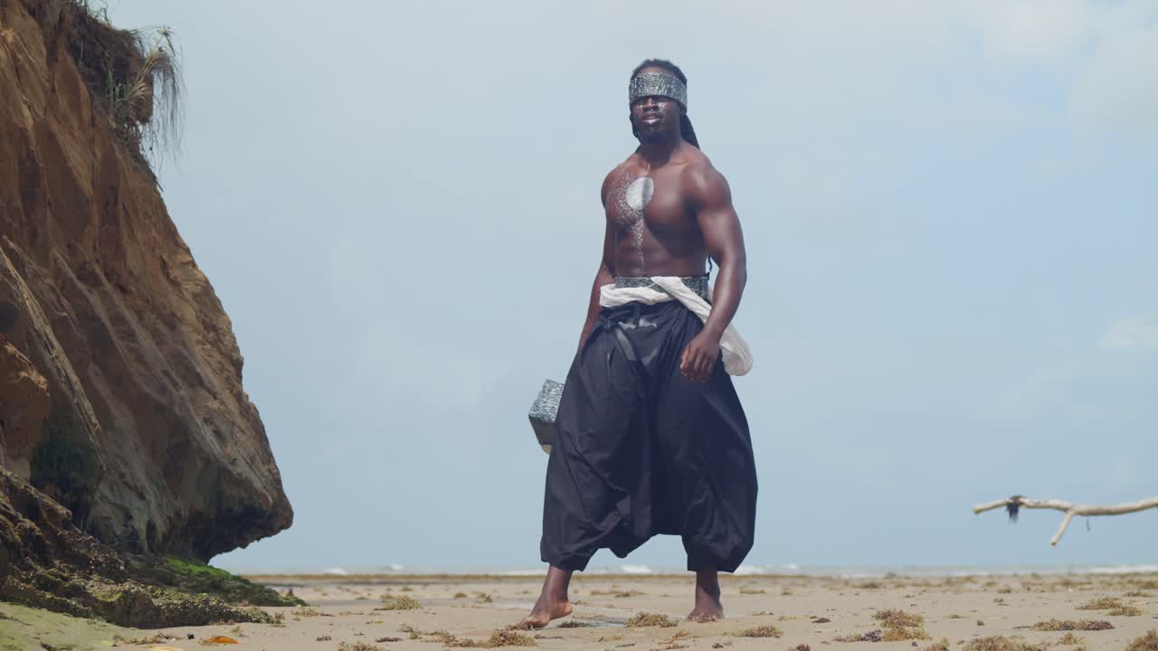 Immersed in his Nekharis cosplay, a muscular, dark-skinned man is prominently featured on a tropical beach