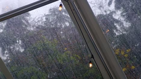 light bulbs attached to cable on transparent tent, heavy rain