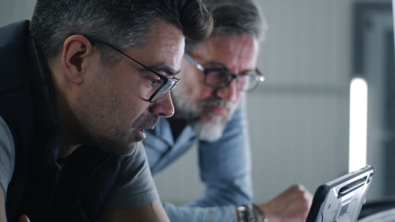 Two men collaborating and looking at a tablet