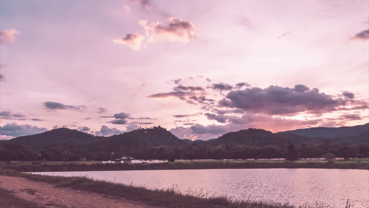 cielo de la puesta del sol del lapso de tiempo sobre el lago y la montaña en tono dulce caliente