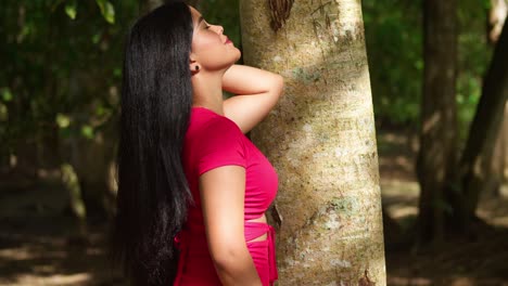 beautiful woman in red dress posing in a forest