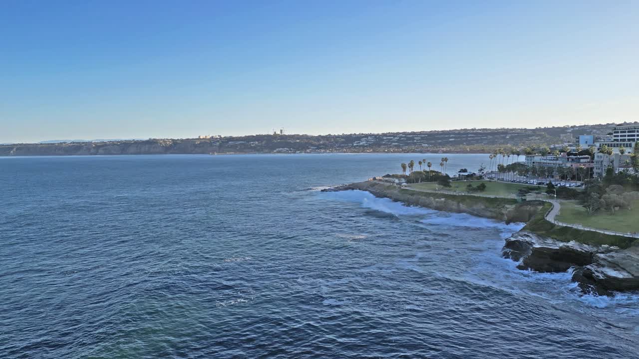 패닝 드론 샷은 킹 타이드 동안 캘리포니아 라홀라의 절벽에 부서지는 파도와 함께 수평선과 흔적을 보여줍니다.