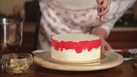 woman decorating a beautiful red-iced cake