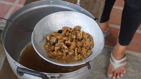 Tamarind-pulp-being-strained-in-colander-to-prepare-tamarind-sauce