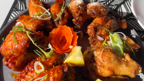 hot and spicy chicken wings in sticky bbq sauce with spring onion and a lemon slice, asian cuisine, 4k shot