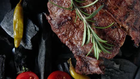 grilled steak with rosemary on charcoal