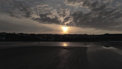 Tarde-Nublado-Dorado-Atardecer-Colores-A-Través-De-Benllech-Playa-Silueta-Costa-Anglesey-Vista-Aérea-Lento-Aumento