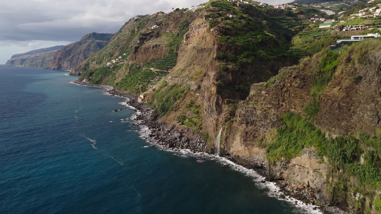 Vista aerea di spettacolari scogliere costiere con cascata e onde oceaniche
