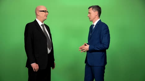 dos hombres en trajes saludando y hablando