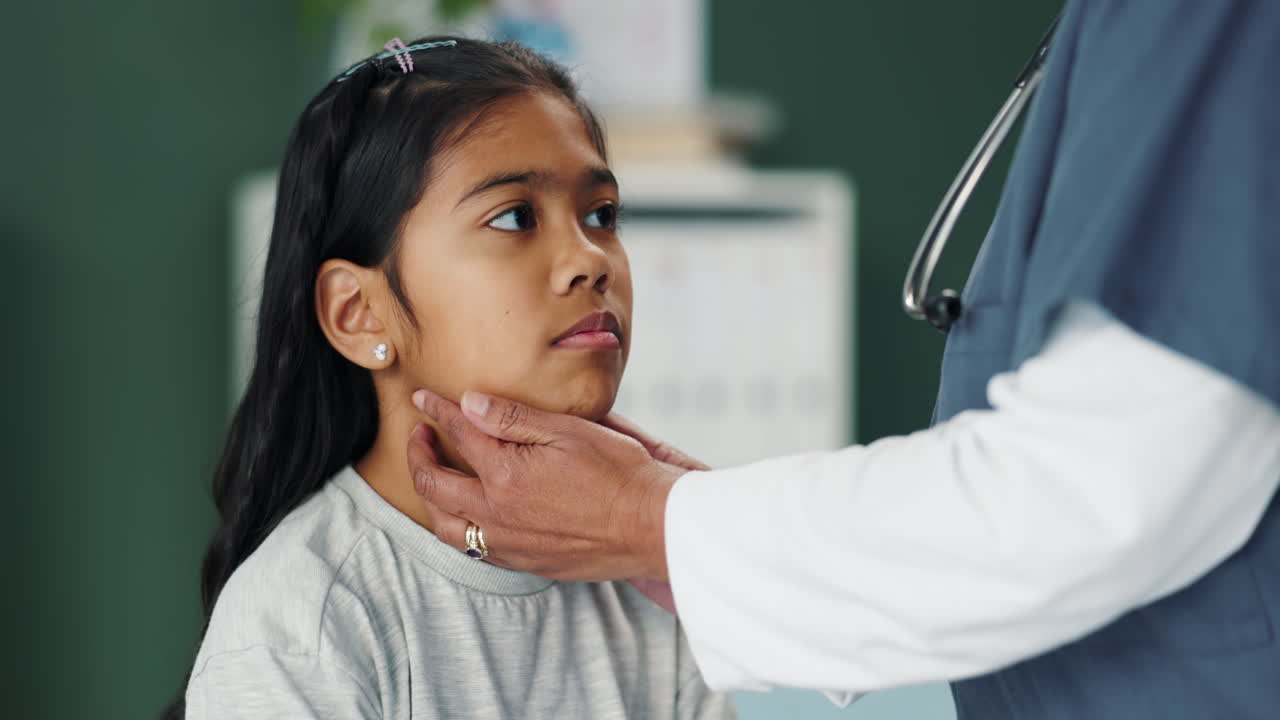Doctor examining a young girl's throat