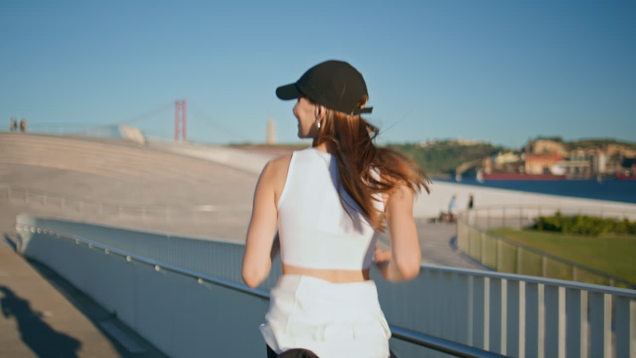 Back girl jogging sunlight wearing cap closeup. Young sportswoman training