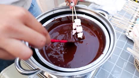 sumergiendo golosinas en una rica fondue de chocolate