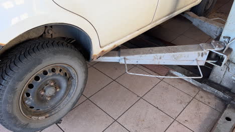 rusty wheel of a vintage car with trailer hitch, close-up