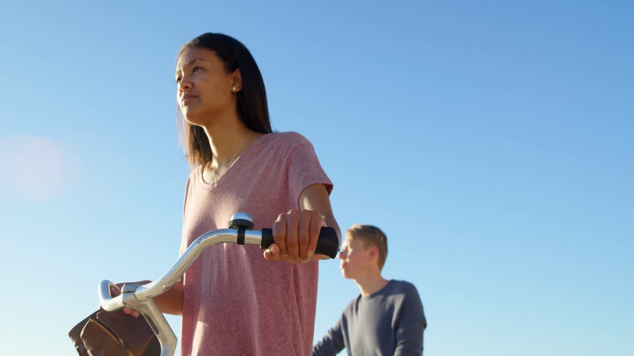 해변 4k에서 자전거를 타고  ⁇ 고 있는 젊은 부부