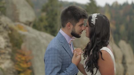 novio con la novia en una colina de la montaña en el bosque. pareja de bodas