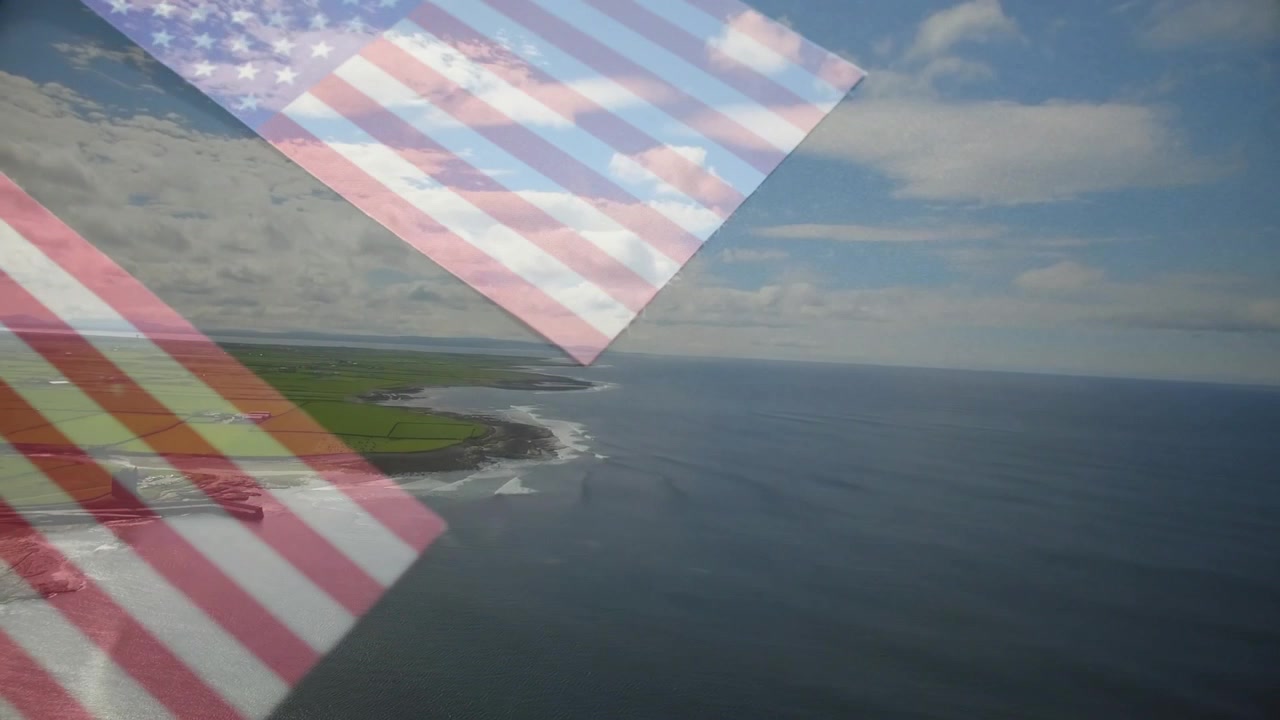 Bandiere americane tenui che appaiono, fluttuano e si sovrappongono su una costa aerea, attirando lo sguardo dalla terraferma.