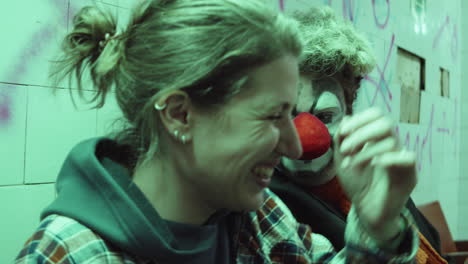 clown chatting with cheerful girlfriend in subway