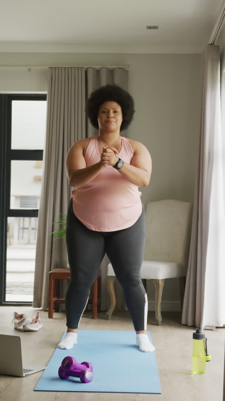 Video verticale di donna birazziale curvy che si allena a casa