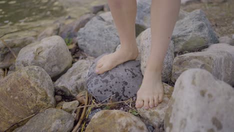 Foot-view-of-attractive-girl-walking-on-a-rocky-beach