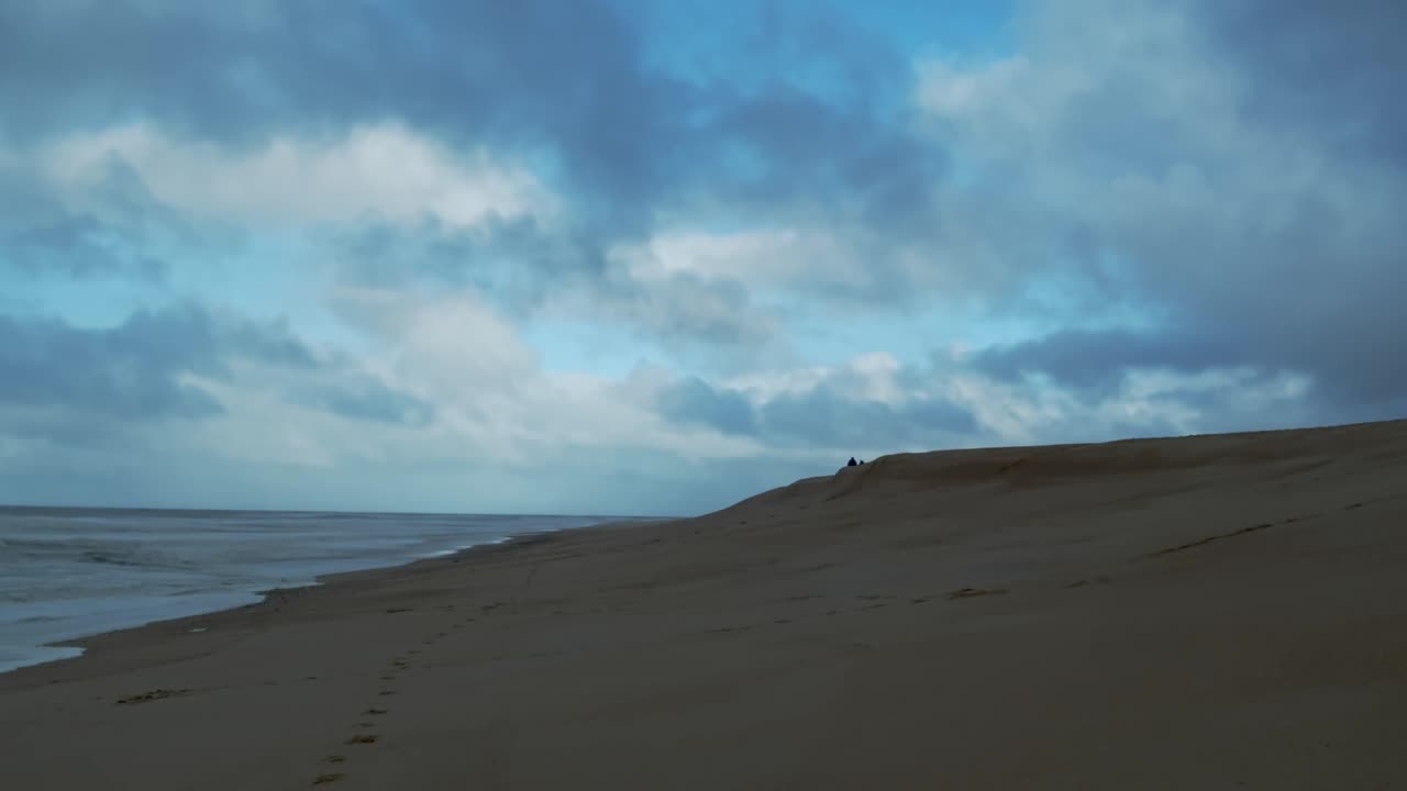 Moody Clouds drift over Nazare coast sandy beach Portugal Timelapse