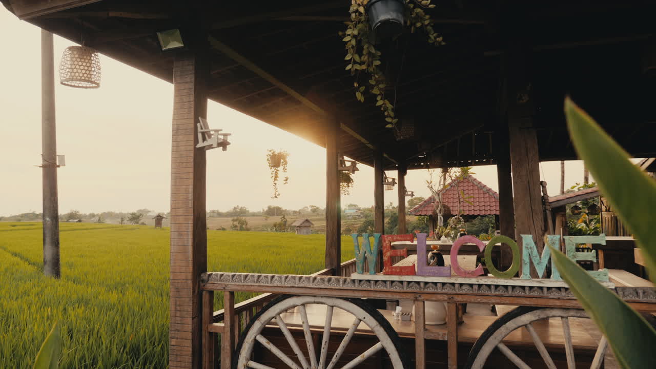 Wooden Porch with Welcome Sign Overlooking Rice Paddy Fields at Sunrise/Sunset