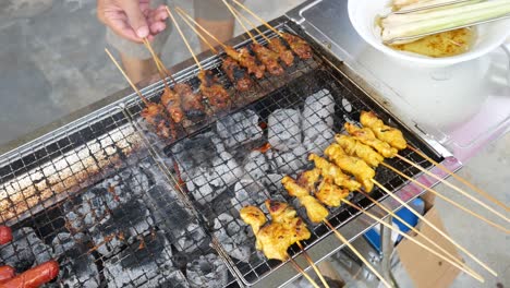 a man is grilling satay