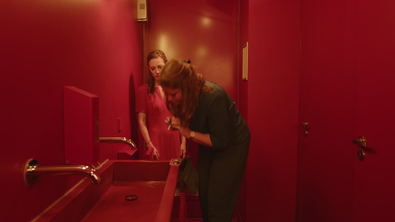 Due donne che fanno uso di sostanze in un bagno pubblico.