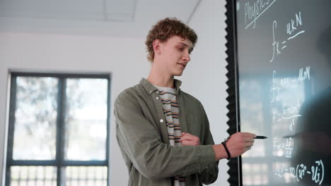 teacher explaining physics on blackboard