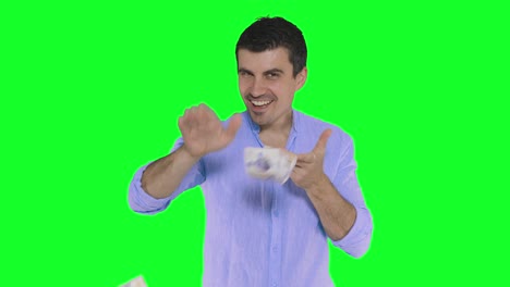 A-handsome-young-man-in-a-white-shirt-throwing-money-and-looking-at-the-camera,-green-screen