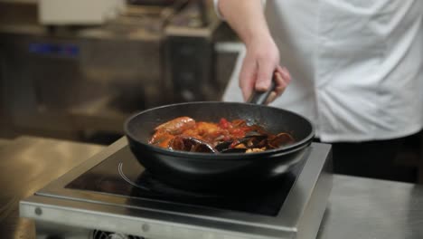 chef cooking seafood dish in a pan