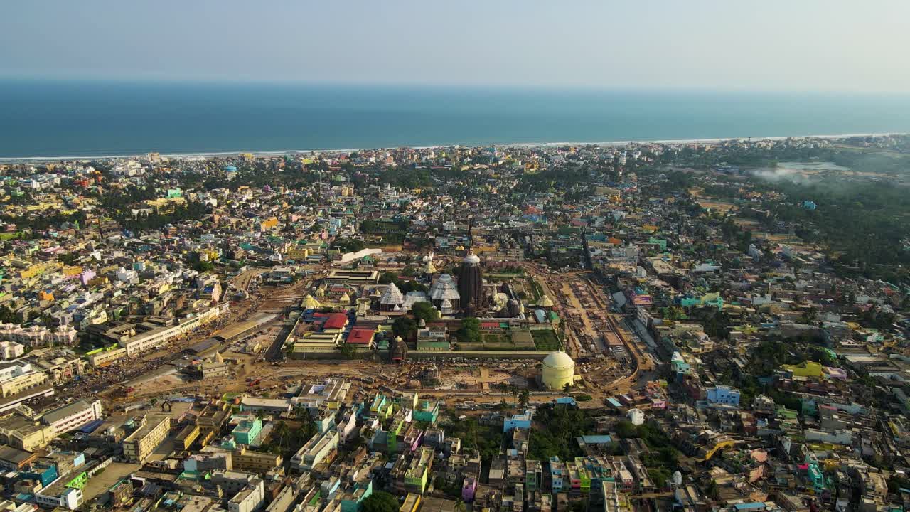 High-altitude aerial drone shot of a natural rock formation emerging from the ocean near Vizag, framed by the endless sea.