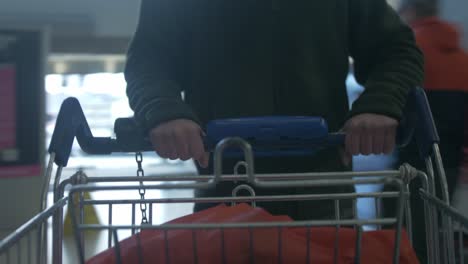 pov pushing shopping trolley in shopping center 4k