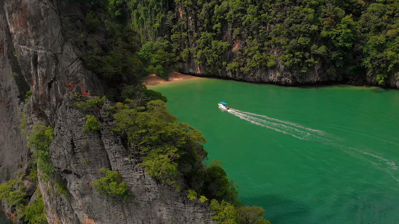 Cảnh quay từ drone trên cao về một chiếc thuyền cao tốc đang tiến đến bãi biển hoang vắng ở Vịnh Pang Na trên Đảo Koh Yao Noi, Thái Lan