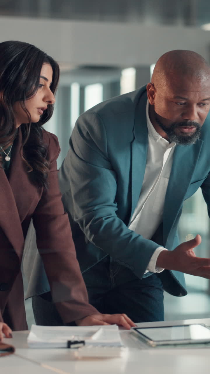 Two Business People Discussing Work on a Tablet in an Office