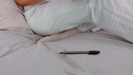 woman writing in a notebook in bed