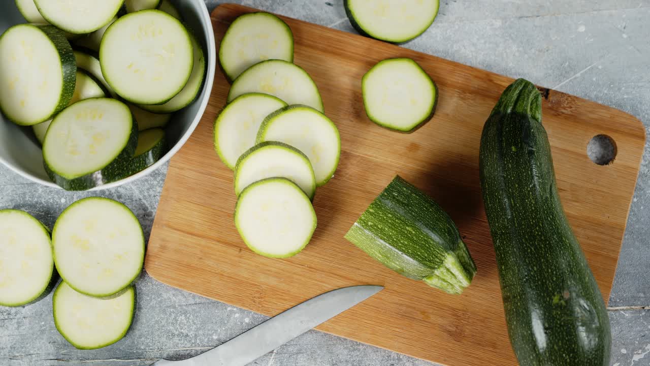 보드 위에 개진 둥근 zucchini 조각을 천천히 회전합니다.