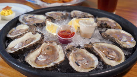 una docena de ostras en media concha, plato de ostras crudas recién desvainadas