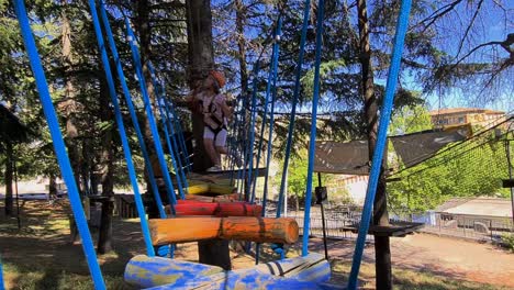 brave girl child have fun overcoming obstacles bridge at kids rope adventure park