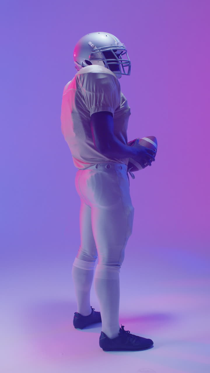 video vertical de un jugador de fútbol americano afroamericano con iluminación púrpura de neón