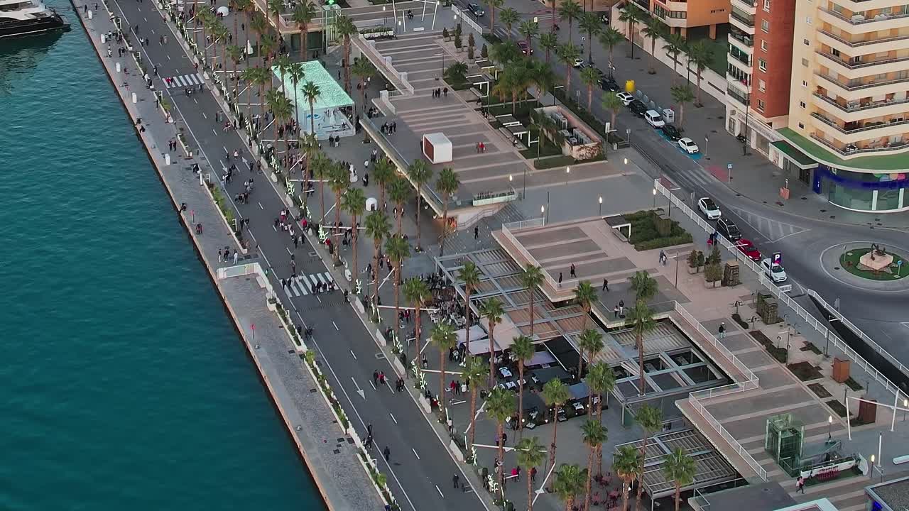 Persone che passeggiano sul lungomare di Malaga, in Spagna, durante il tramonto