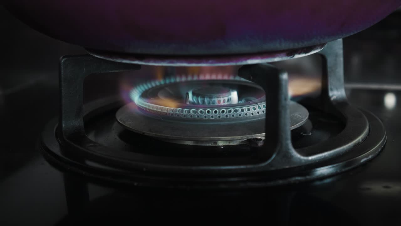 부에서 파란색과 빨간색으로 불타는 불꽃이 있는 검은색 가스 스토브의 비디오