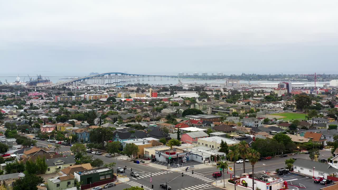 Drone che vola verso il ponte Coronado vicino al centro di San Diego alle prime luci del mattino, con gli edifici circostanti visibili.