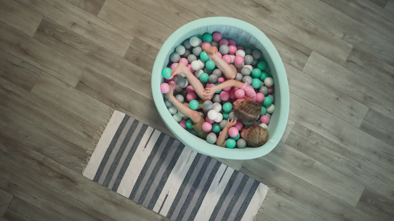 hermana y hermano juegan en el lavabo de juguetes riendo y gritando