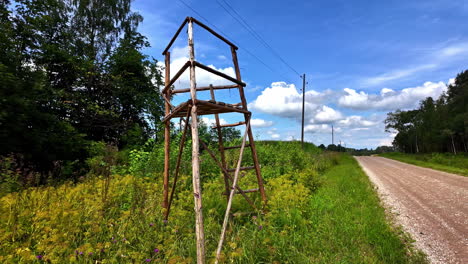 abandoned lookout post on the side of a road in the village with trees and thick bushes on the sides