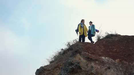 the active man and woman walking on rocks with backpacks